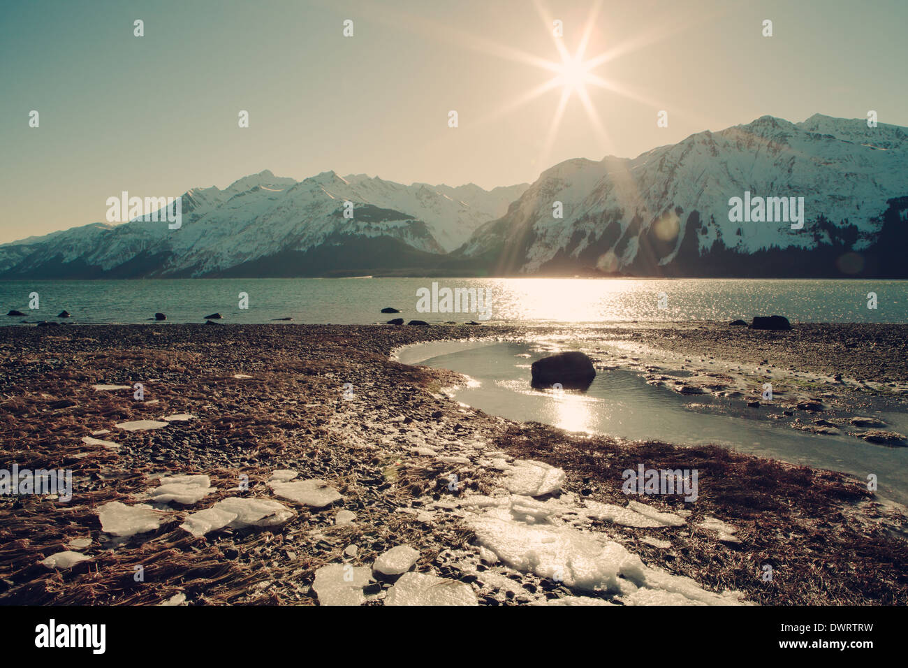 Gelido inverno beach in Alaska con sunburst, textures aggiunto per un look vintage. Foto Stock