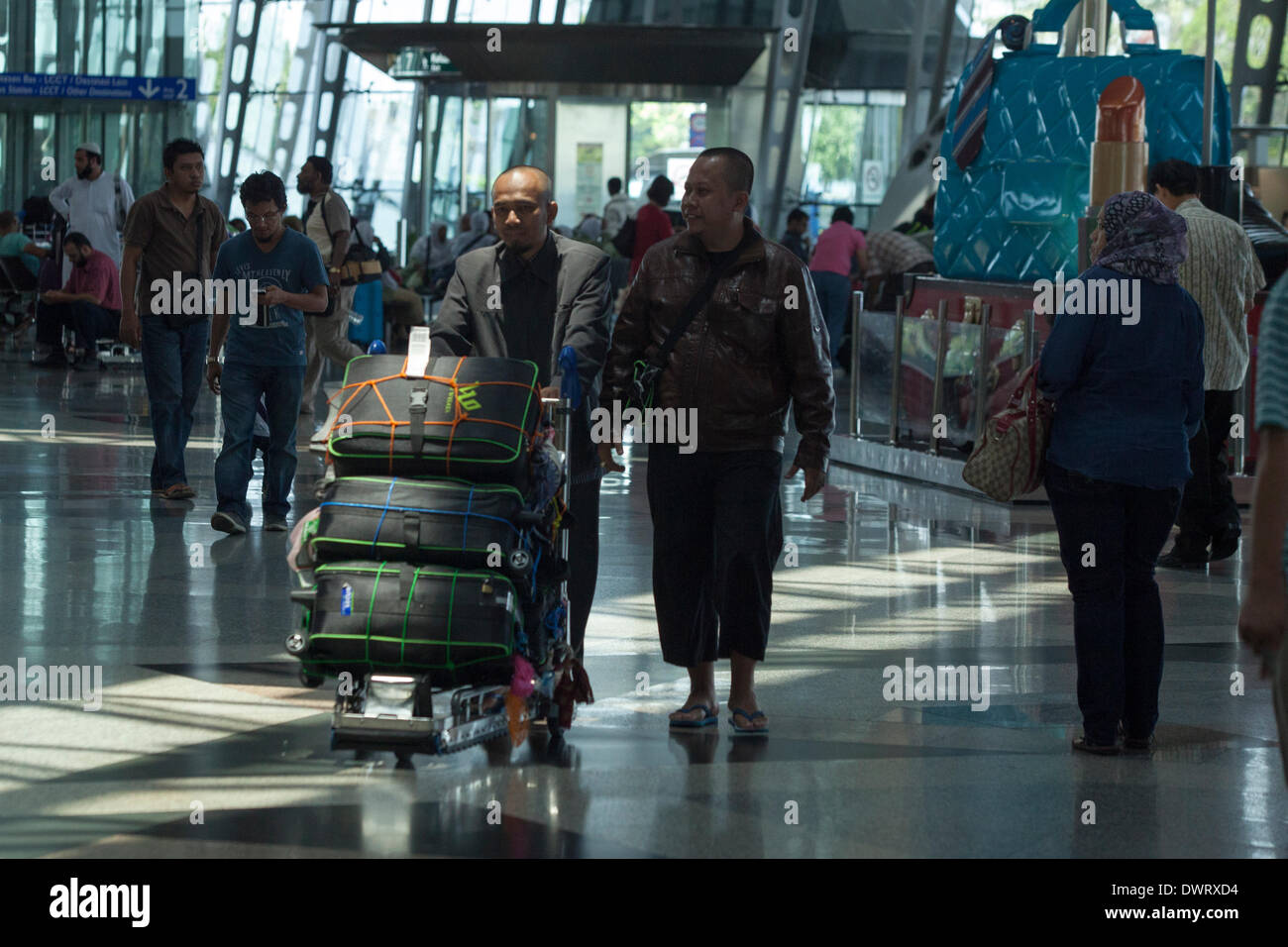 Sepang, Malesia. 11 marzo 2014. I viaggiatori fanno la loro strada attraverso la sala partenze presso l'Aeroporto Internazionale di Kuala Lumpur (KLIA) a Sepang, in Malesia Credito: Asia File/Alamy Live News Foto Stock