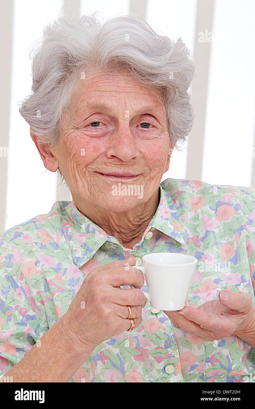 Persona anziana con bevanda calda Foto Stock