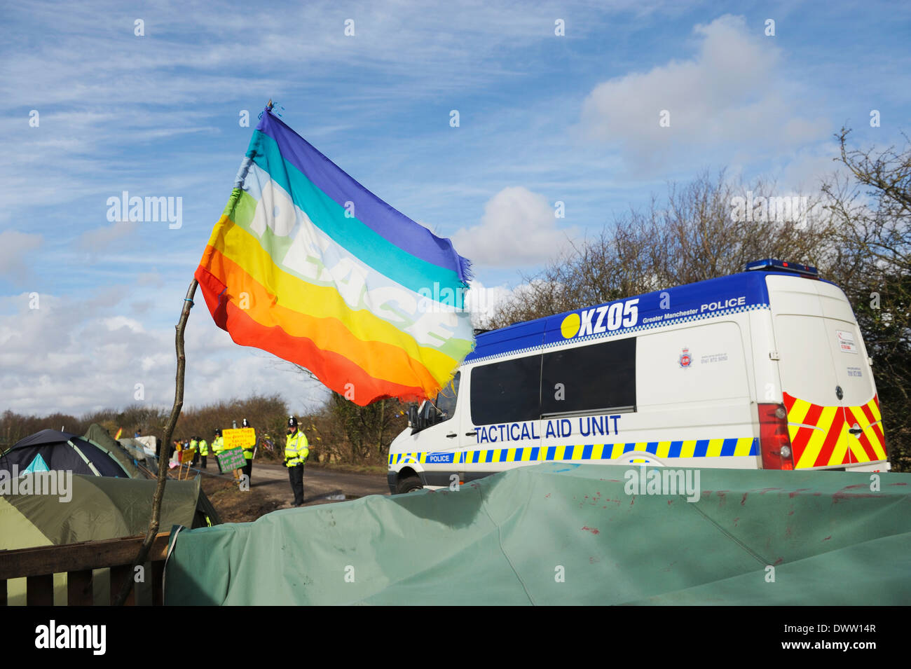 Ausilio tattico unità di guida del veicolo oltre una bandiera della pace come conduce i veicoli e i manifestanti per l'iGas sito di perforazione. Foto Stock