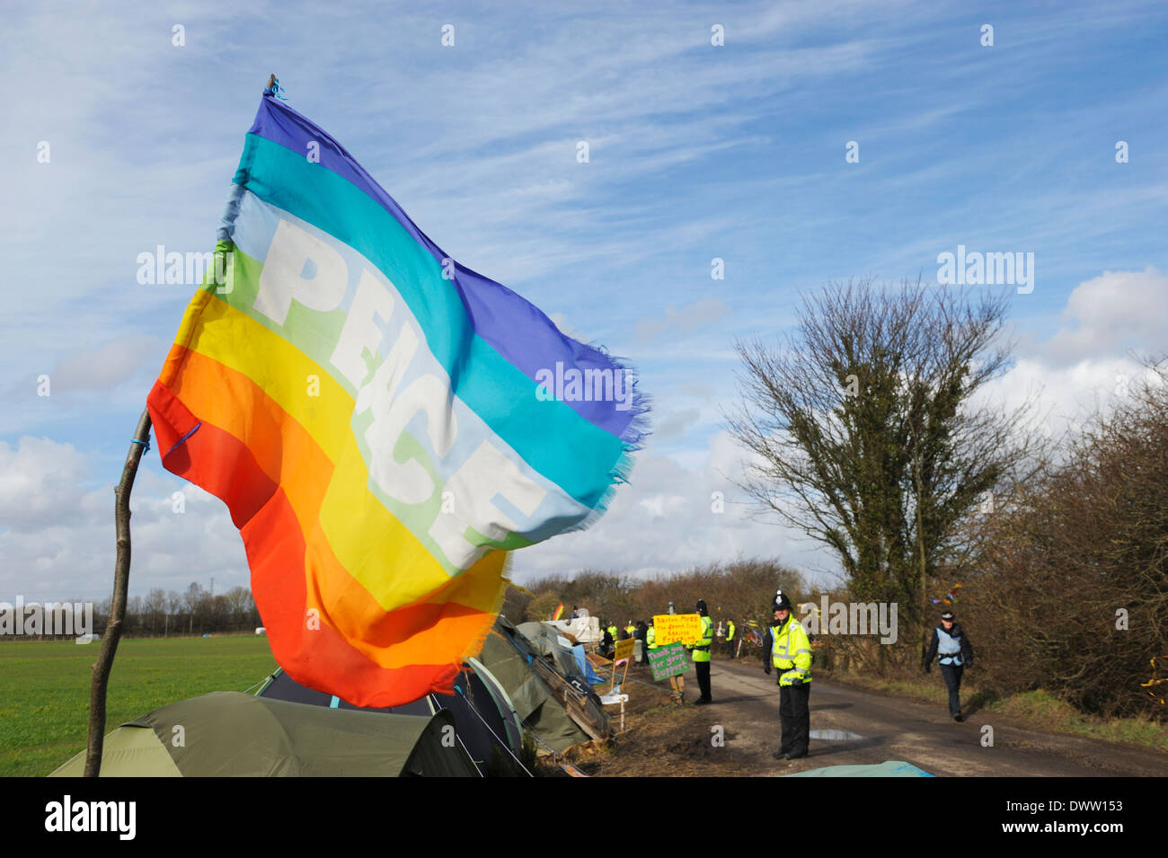 Bandiera della Pace volare nel vento come linea di polizia di Barton protezione Moss Camp prima di manifestanti 'lento a piedi' consegna del sito Foto Stock