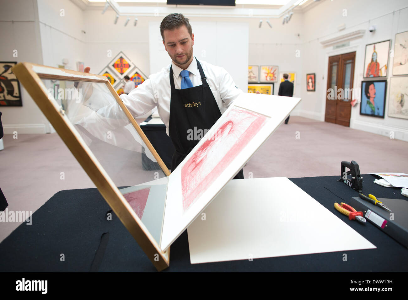 Sotheby's New Bond Street, Londra, Regno Unito 13 marzo, 2014. Sotheby's asta di stampe & multipli, vecchio maestro, moderne e contemporanee, London, Regno Unito un curatore prende Edvard Munch 1863 - 1944 " il bambino malato I' litografia stampata in rosa, rosso vibrante e molto luce-colore, 1896 fuori del telaio per un collettore per visualizzare. Credito: Jeff Gilbert/Alamy Live News Foto Stock