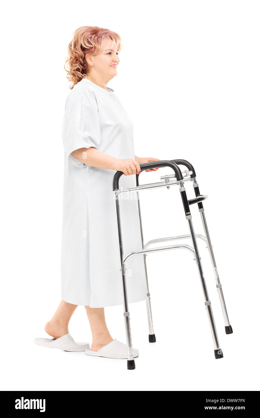 A piena lunghezza Ritratto di un paziente di sesso femminile a piedi con walker isolati su sfondo bianco Foto Stock