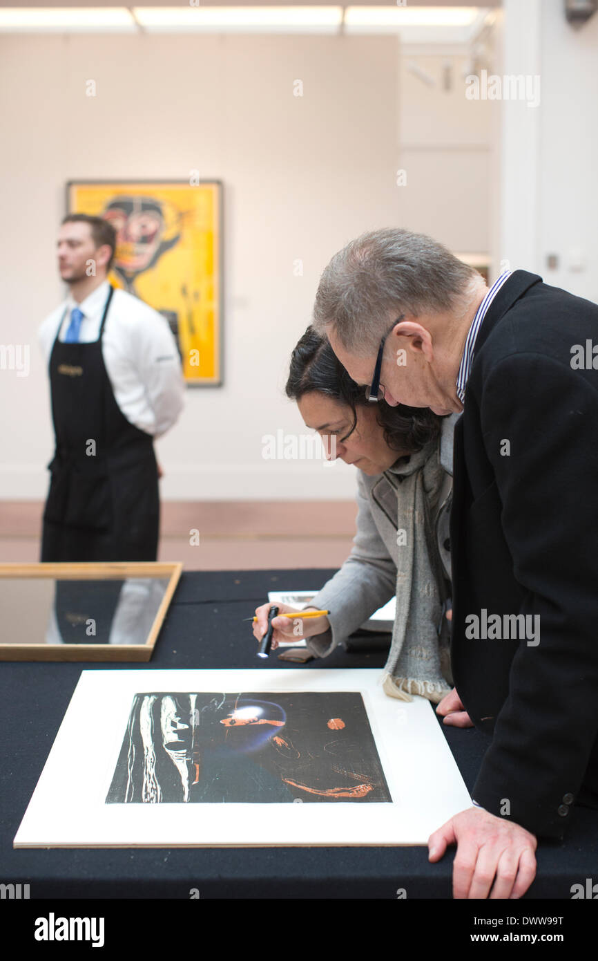 Sotheby's New Bond Street, Londra, Regno Unito 13 marzo, 2014. Sotheby's asta di stampe & multipli, vecchio maestro, moderne e contemporanee, London, Regno Unito un collezionista guarda Edvard Munch 'MELANCHOLY III' Xilografia stampata in blu, ocra, luce-grigio e nero, 1902, in dettaglio prima di procedere all'asta da Sotheby's, Londra. Credito: Jeff Gilbert/Alamy Live News Foto Stock