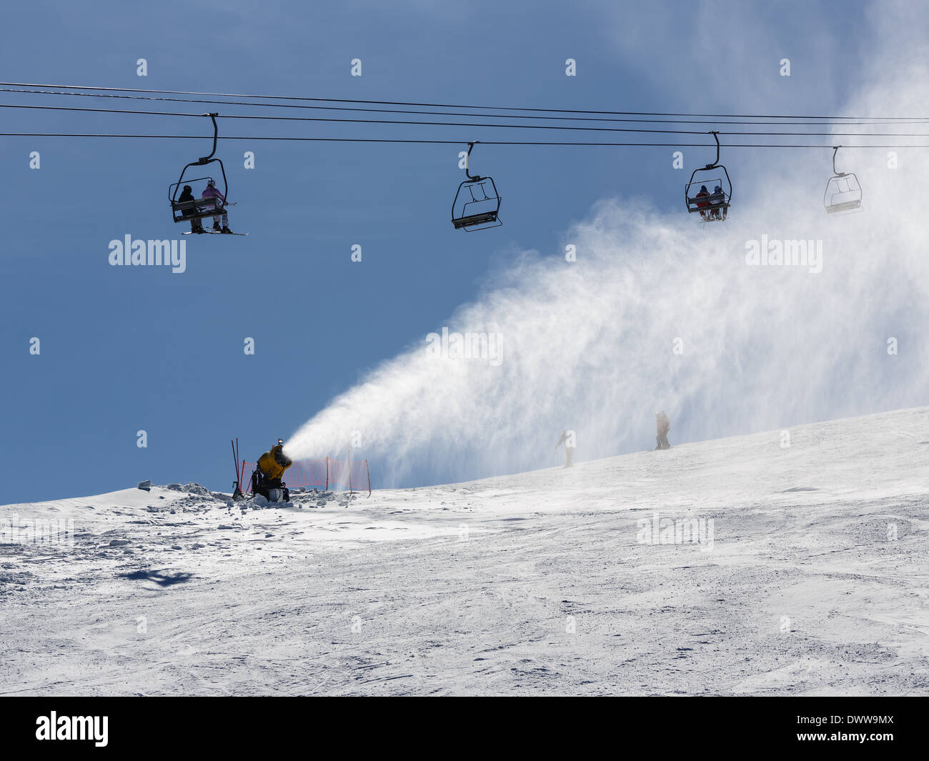 Irrorazione di innevamento artificiale neve sulle piste per sciatori in montagna Foto Stock