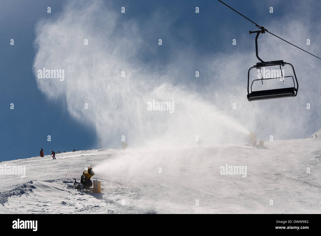 Irrorazione di innevamento artificiale neve sulle piste per sciatori in montagna Foto Stock