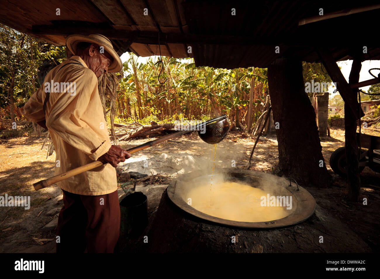 Moises Ibarra boils spremuta di canna da zucchero per fare il raspadura, una torta di zucchero, nella provincia di Cocle, Repubblica di Panama, America Centrale. Foto Stock