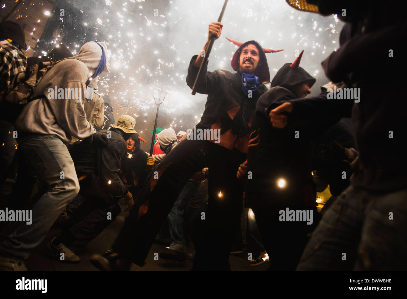 La gente ballare sotto i fuochi d'artificio di un correfoc, una tradizione catalana Foto Stock