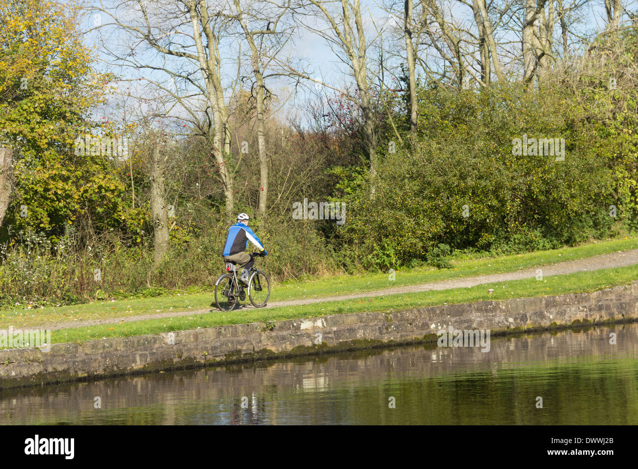 Ciclista sulla strada alzaia del canale Leeds-Liverpool a Aspull, Lancashire. L'alzaia è parte dell'Whelley linea Loop cycleway Foto Stock