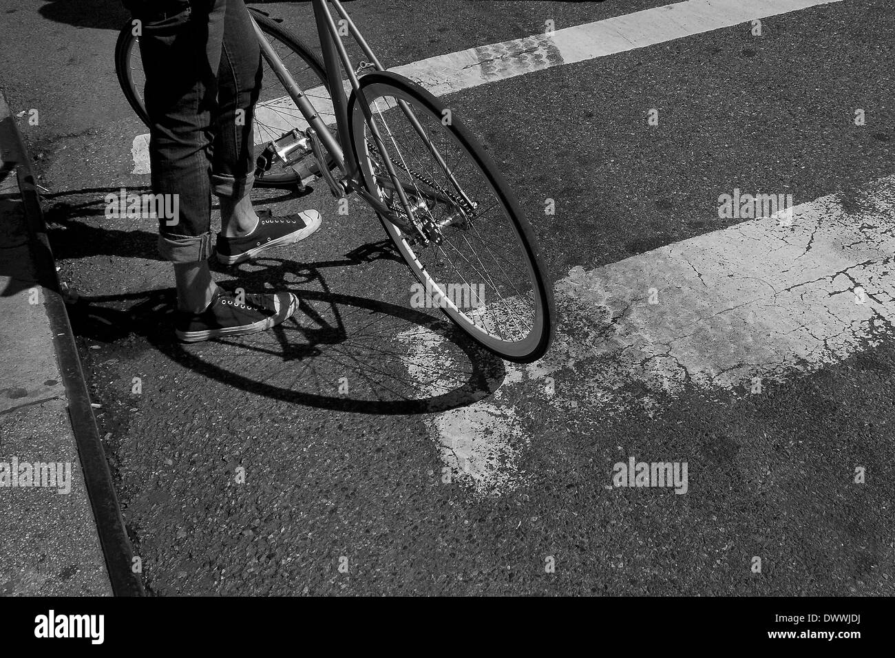Vista di un ciclista per le gambe con la bicicletta in appoggio contro la sua gamba, New York, Stati Uniti d'America Foto Stock