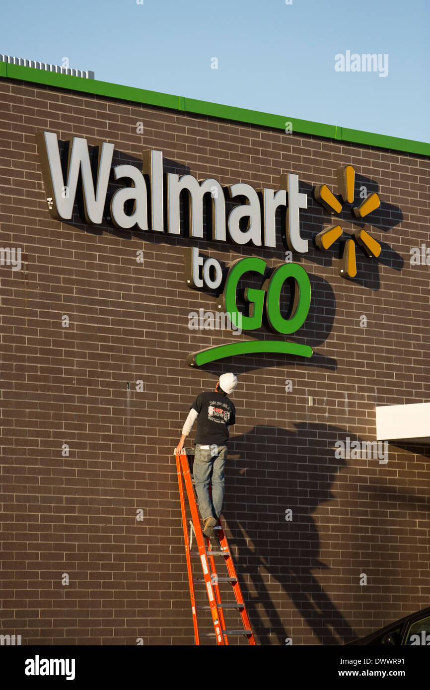 Imprenditore lavorando sul segno della nuova Walmart per andare concetto convenience store in costruzione in Bentonville, AR, Stati Uniti d'America. Foto Stock