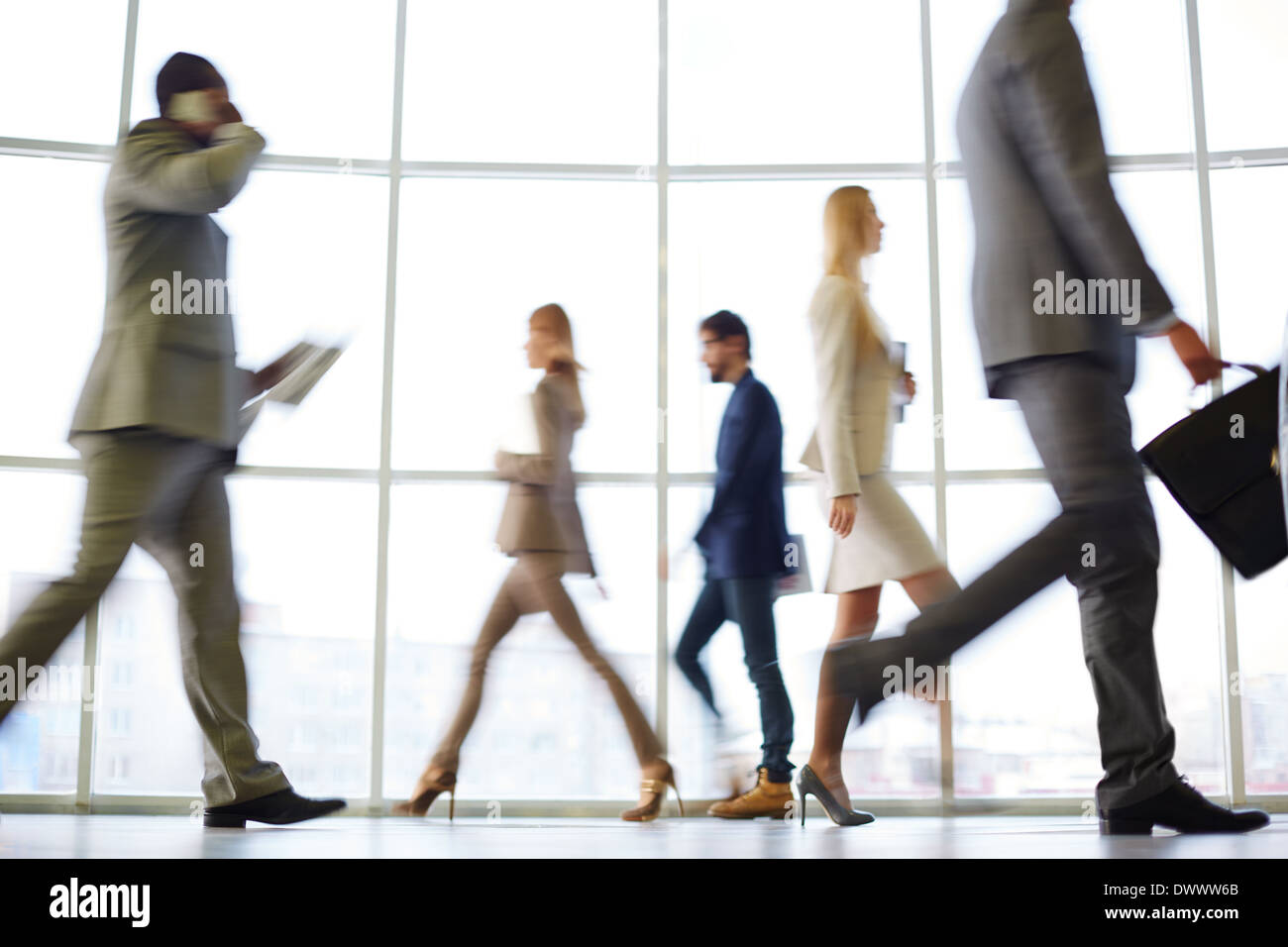 Lavoratori di colletto bianchi andando giù il corridoio ufficio alla fine della giornata di lavoro Foto Stock