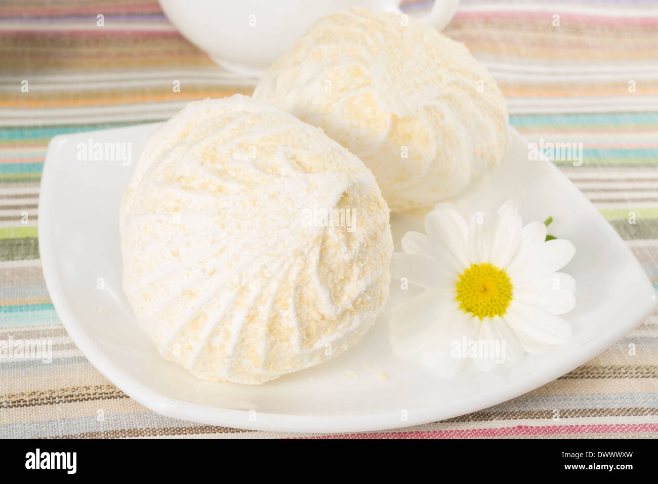 Aria marshmallows su una piastra con fiore camomilla Foto Stock