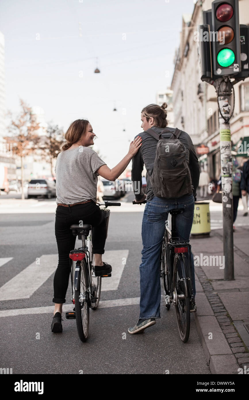 Vista posteriore del giovane con le biciclette in attesa di zebra crossing presso la strada di città Foto Stock
