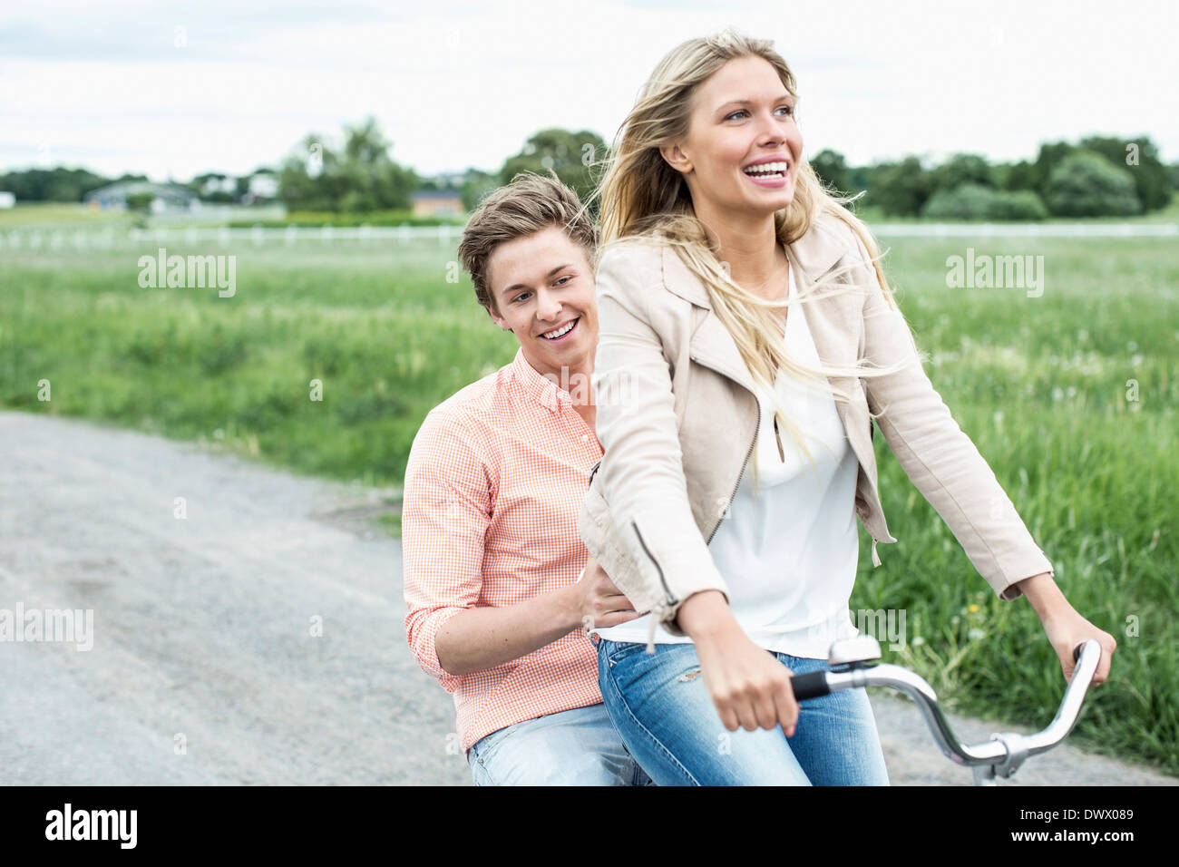 Felice coppia giovane godendo di bicicletta in campagna Foto Stock