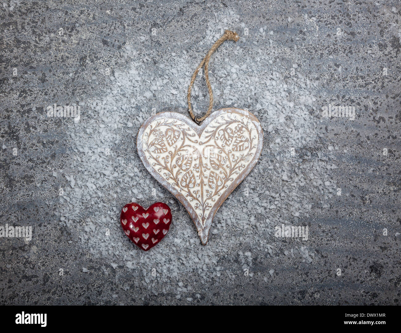 In legno intagliato e cuori di pietra su un calcare grigio sfondo Foto Stock