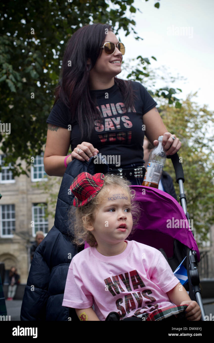 Una giovane ragazza in un buggy con un piccolo tartan hat in attesa sul Royal Mile prima di un pro-indipendenza marzo a Edimburgo. Foto Stock
