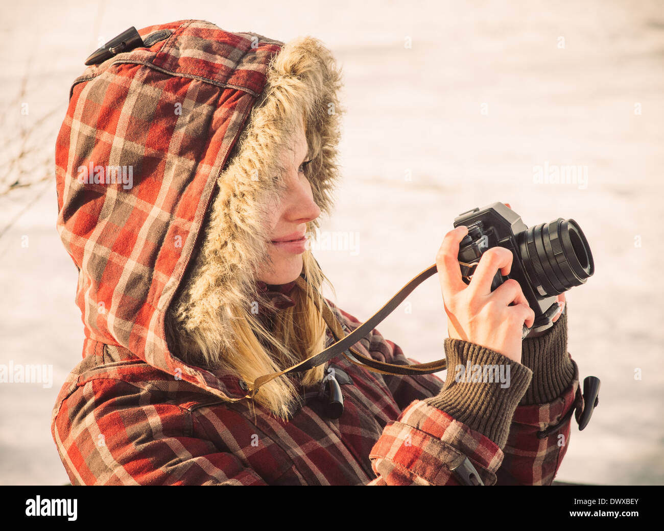Giovane donna con retro fotocamera tanga Outdoor Lifestyle con natura invernale sullo sfondo Foto Stock