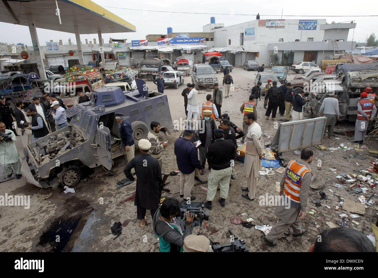 A Peshawar, Pakistan. Il 14 marzo 2014. I poliziotti e le persone si radunano presso il sito di blast nel nord-ovest del Pakistan Peshawar il 14 marzo 2014. Almeno nove persone sono state uccise e 35 altri feriti quando un attentatore suicida ha colpito un veicolo di polizia vicino a Peshawar venerdì. Credito: Xinhua/Alamy Live News Foto Stock