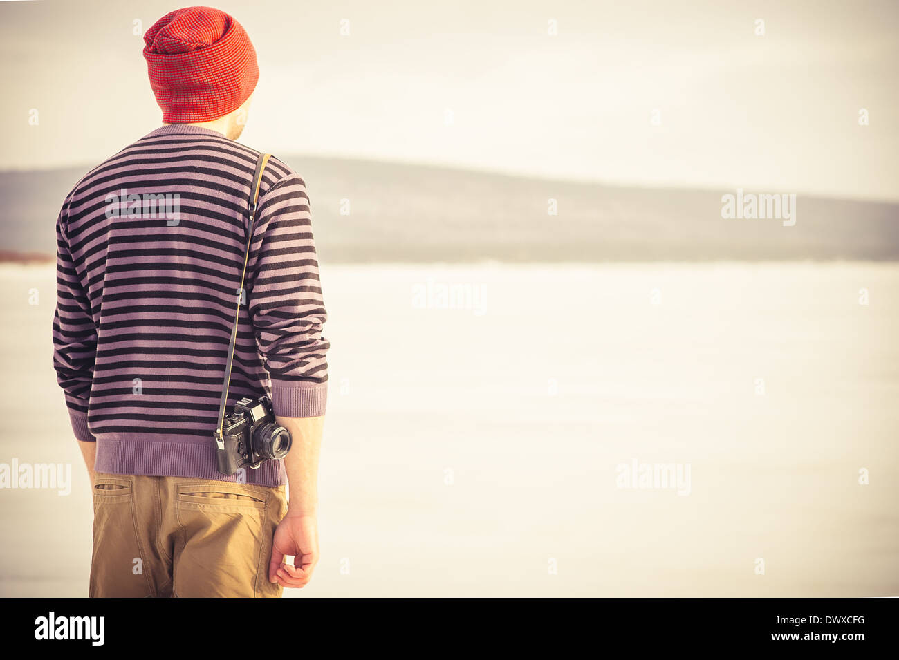 Giovane uomo con retro fotocamera tanga Outdoor Lifestyle con montagne natura invernale sullo sfondo Foto Stock