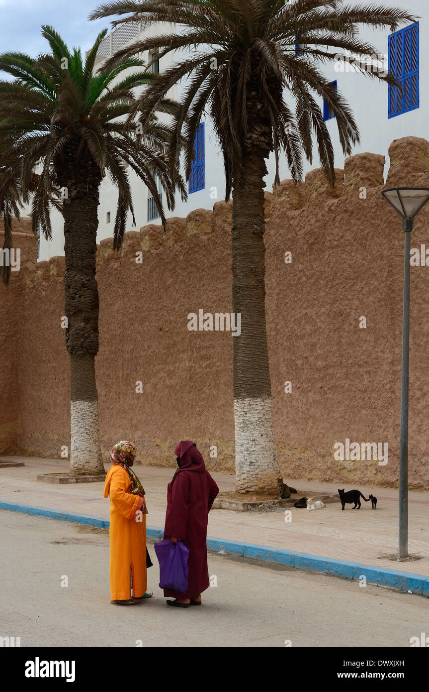 Due donne in abito tradizionale in chat sulle strade di essaouira marocco Foto Stock