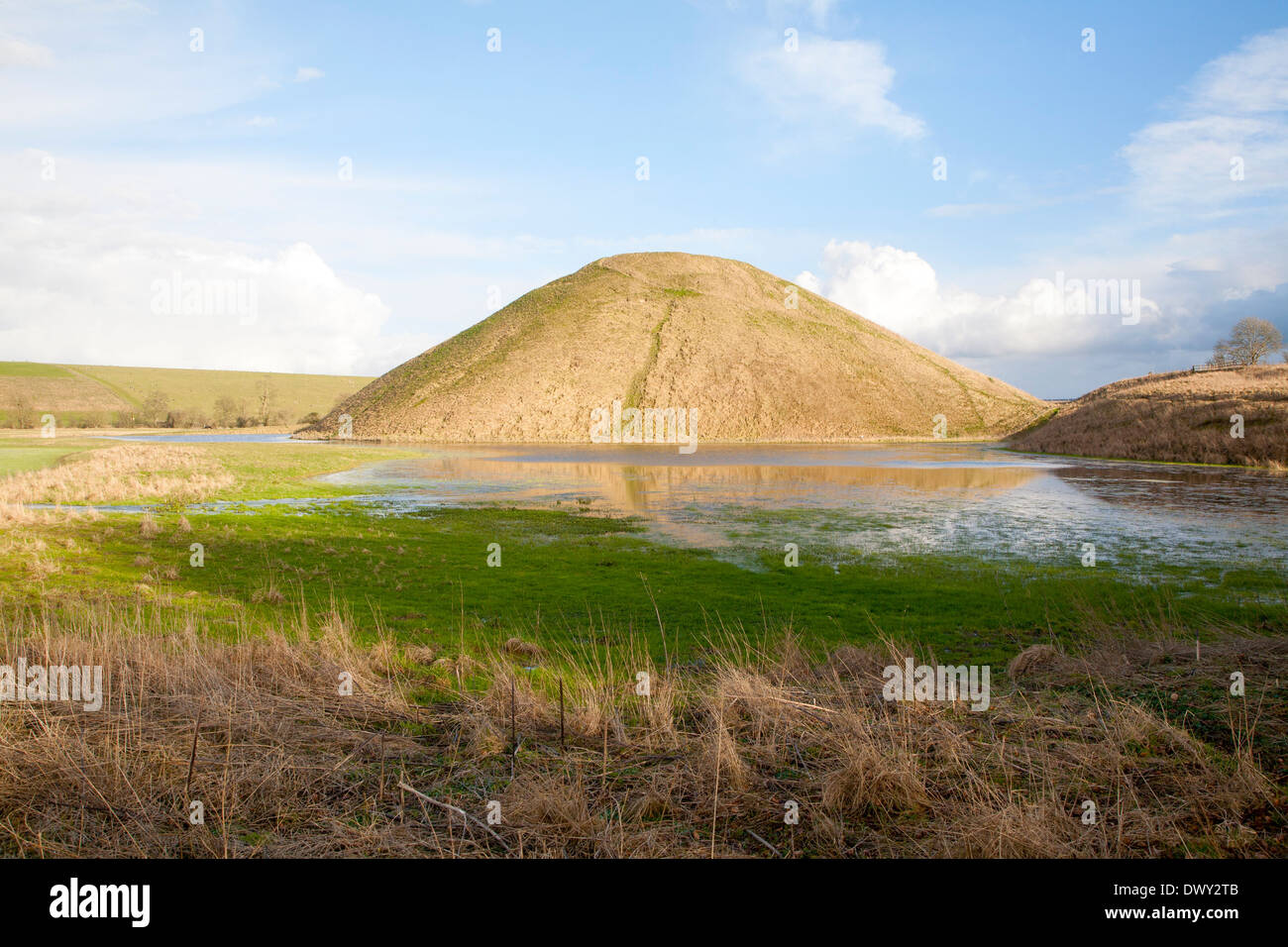 Silbury Hill del Neolitico antico manmade chalk mound in Avebury, Wiltshire, Inghilterra con acqua di inondazione in primo piano Foto Stock