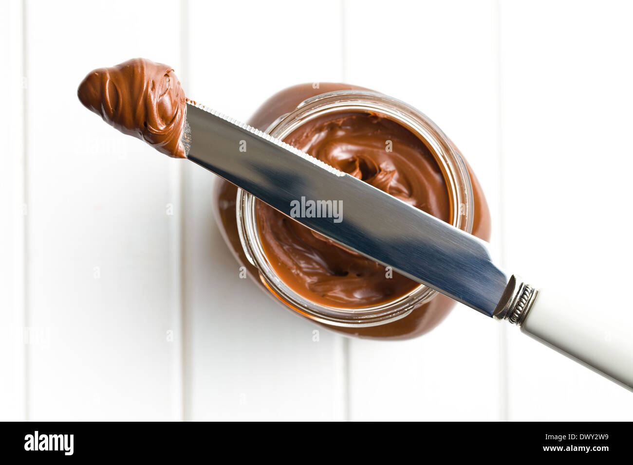 Cioccolato da spalmare con il coltello sul tavolo bianco Foto Stock
