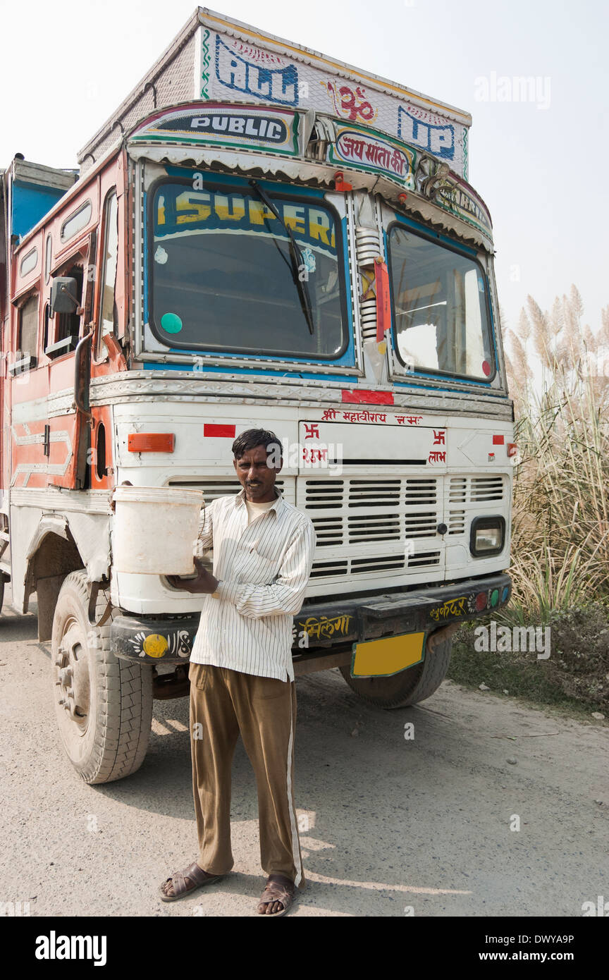 1 Indian uomo in piedi vicino al carrello e mostrando cucchiaio di olio Foto Stock