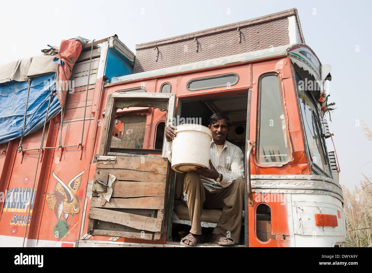1 Indian uomo seduto nel carrello e mostrando cucchiaio di olio Foto Stock