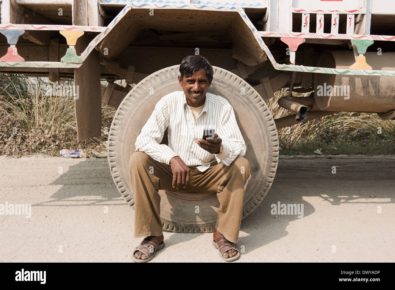 1 Indian uomo seduto vicino a carrello con mobile Foto Stock