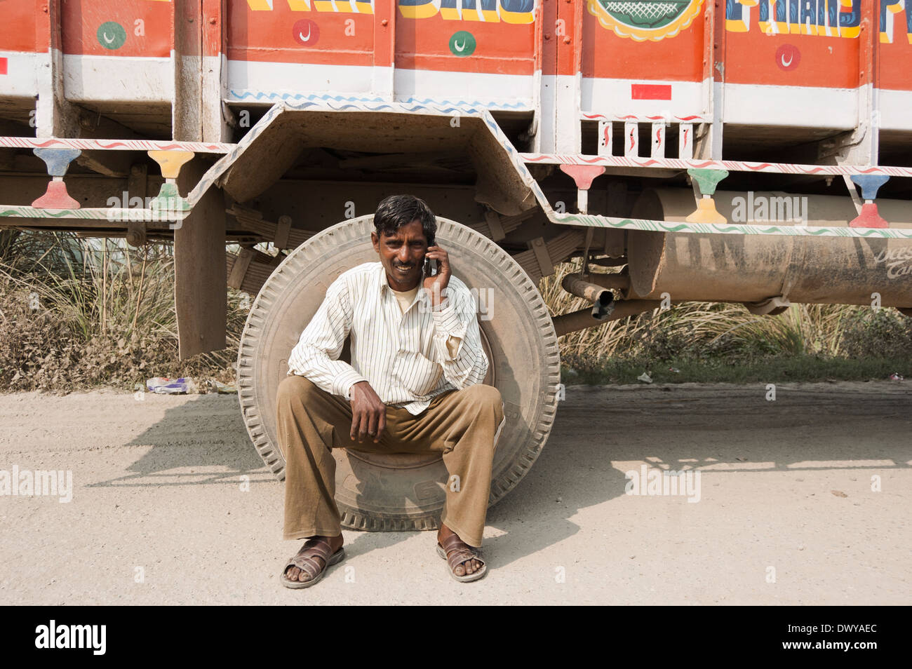 1 Indian uomo seduto vicino a Carrello e parlando con mobile Foto Stock