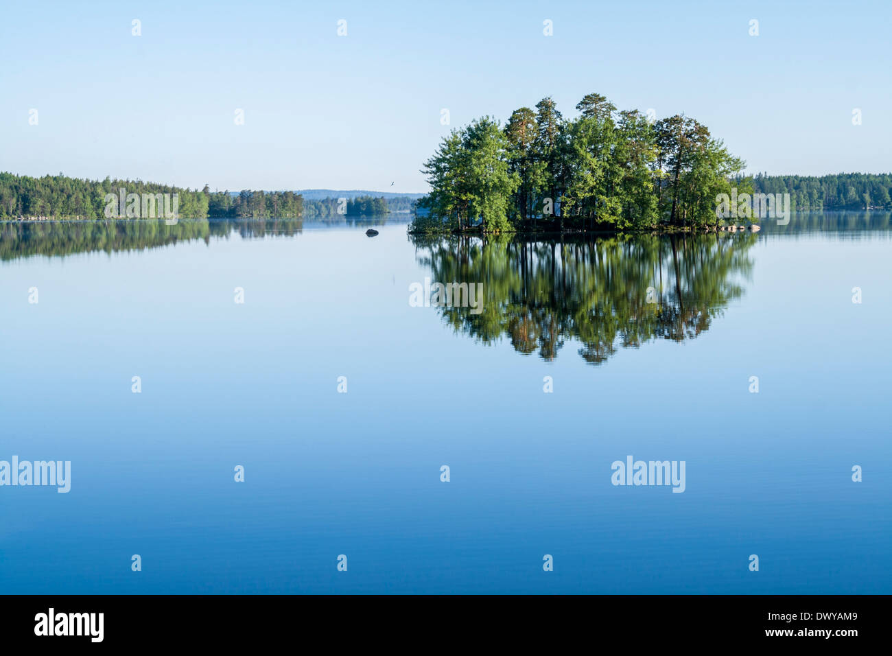 Piccola isola in un lago con molto calma acqua Foto Stock