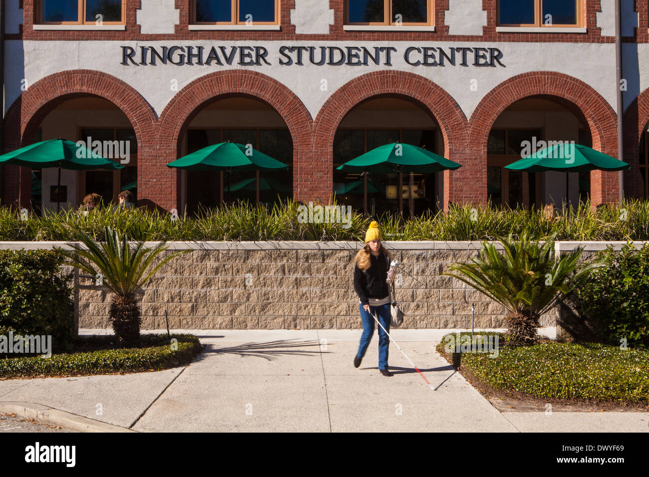 Un cieco donna cammina con un bastone bianco di fronte Flagler College Ringhaver Centro per lo studente in Sant'Agostino, Florida Foto Stock