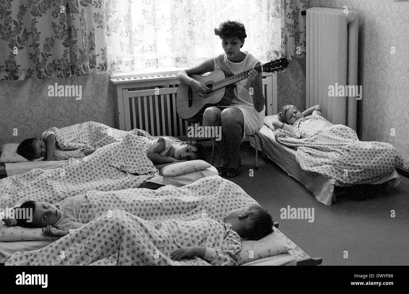 Berlino, gdr, insegnante di scuola materna insieme contro il pan dei figli sulla chitarra Foto Stock