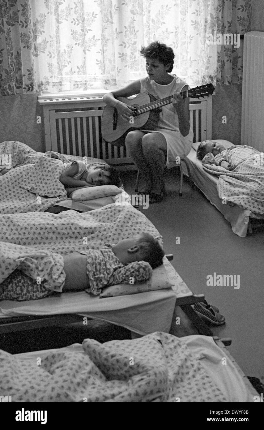 Berlino, gdr, insegnante di scuola materna insieme contro il pan dei figli sulla chitarra Foto Stock