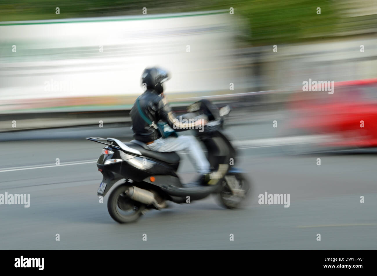 Un driver di scooter in città. Foto Stock