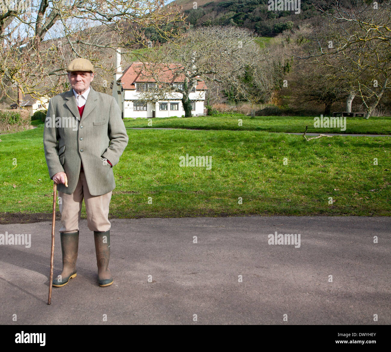 Elegantemente vestito gentleman fuori per la sua passeggiata mattutina nel Bossington, Parco Nazionale di Exmoor, Somerset, Inghilterra Foto Stock