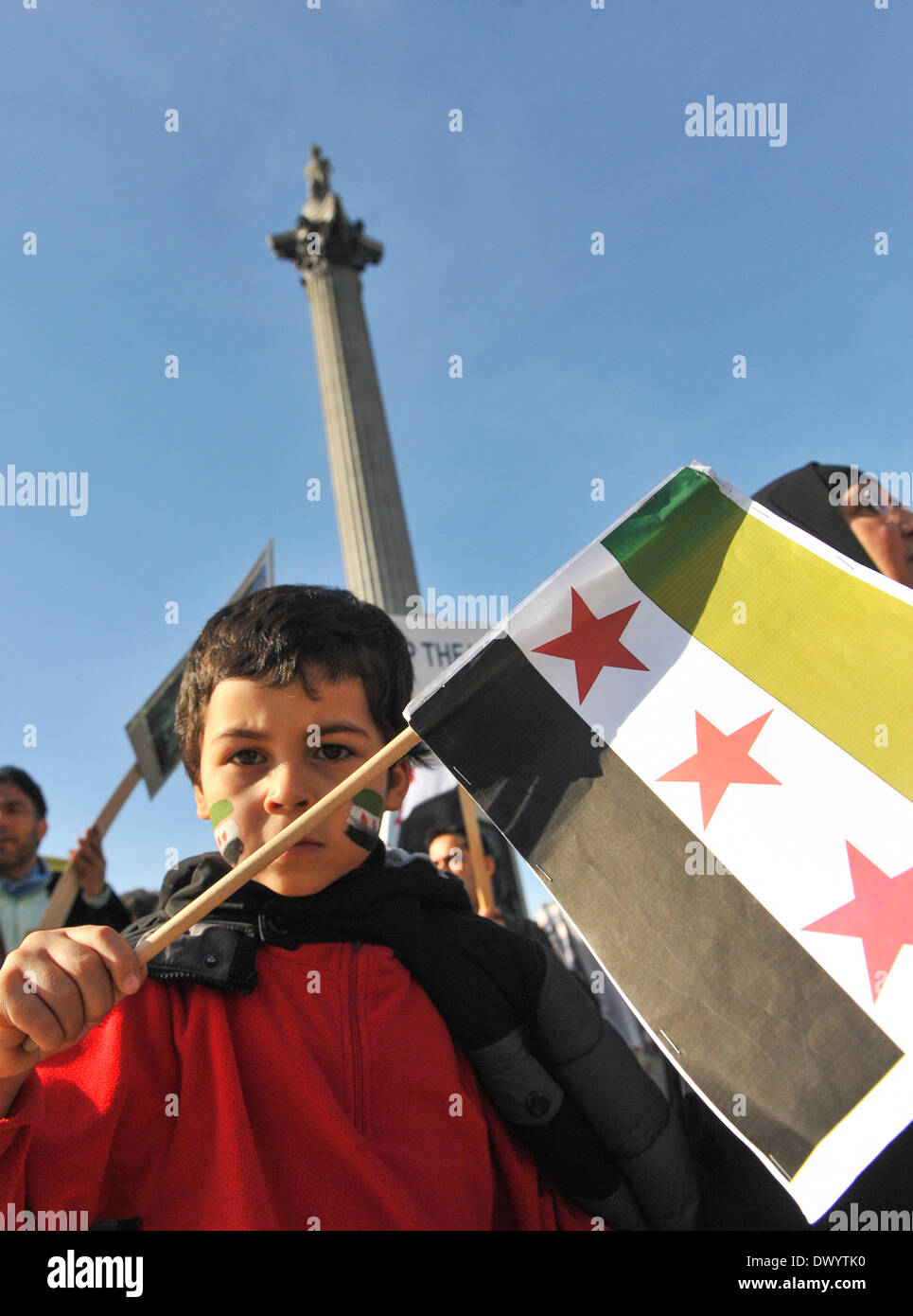 Trafalgar Square, Londra, Regno Unito. Il 15 marzo 2014. Un ragazzo siriano tenendo una bandiera marche passato Nelson nella colonna anti Assad marcia di protesta. Credito: Matteo Chattle/Alamy Live News Foto Stock