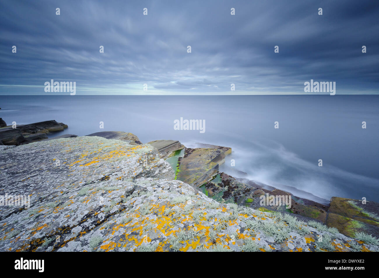 Una lunga esposizione foto di rocce di arenaria e il mare sulla costa a Wick, Caithness, a nord della Scozia. Foto Stock