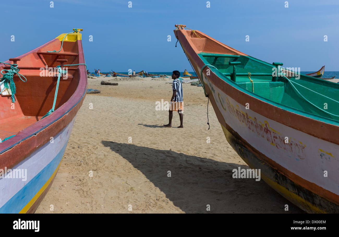 Barche da pesca stand ormeggiata sulla luminosa spiaggia sabbiosa di pescatori in stand by in attesa che la marea di girare in Mamallapuram, India. Foto Stock