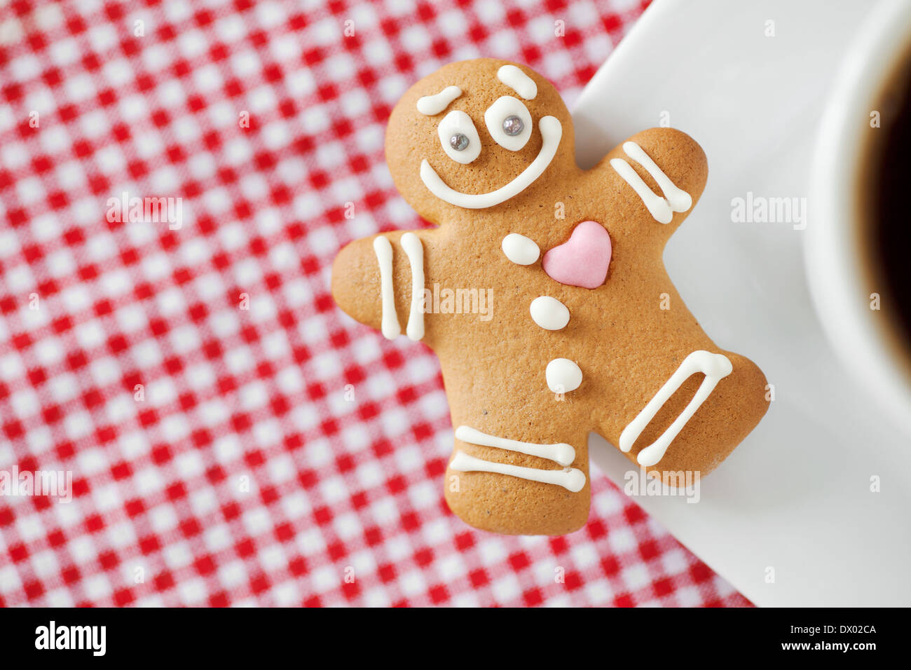 Sorridente omino di pan di zenzero e la tazza di caffè sul tavolo Foto Stock