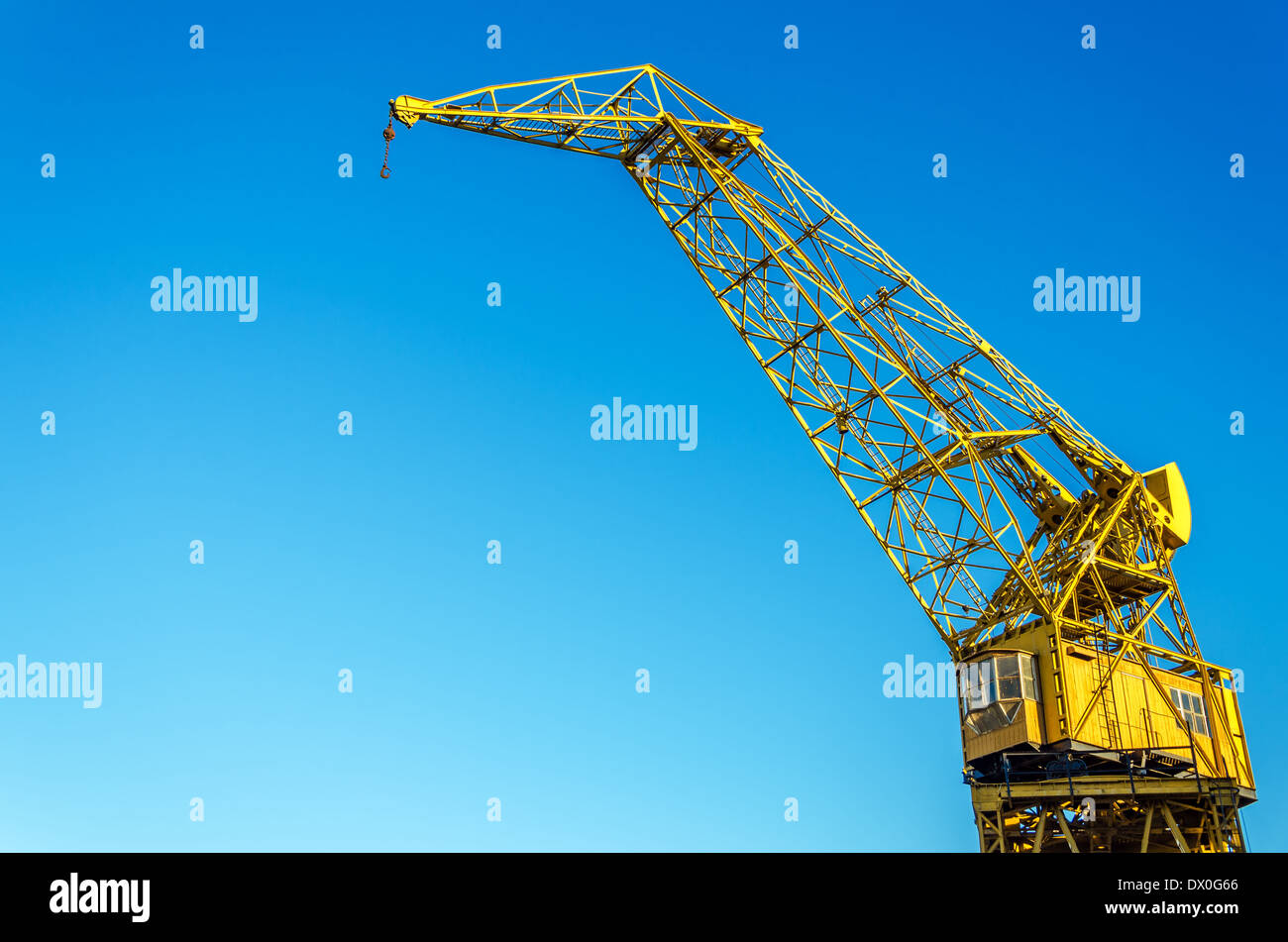 Vecchio yellow crane set contro un cielo blu Foto Stock