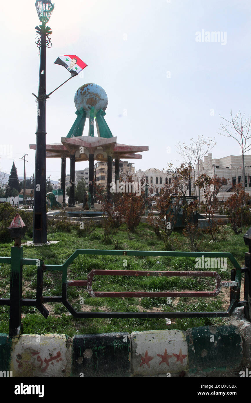 Yabroud. 16 Mar, 2014. Foto scattata il 16 marzo 2014 mostra una bandiera del presidente siriano Bashar al-Assad in un giardino in Yabrud nella periferia di Damasco Capitale della Siria. Le truppe siriane domenica completamente riconquistò la città di Yabroud, rimuovendo i ribelli da quella zona strategica a nord della capitale Damasco, media locali detto. Credito: Bassem tellawi/Xinhua/Alamy Live News Foto Stock