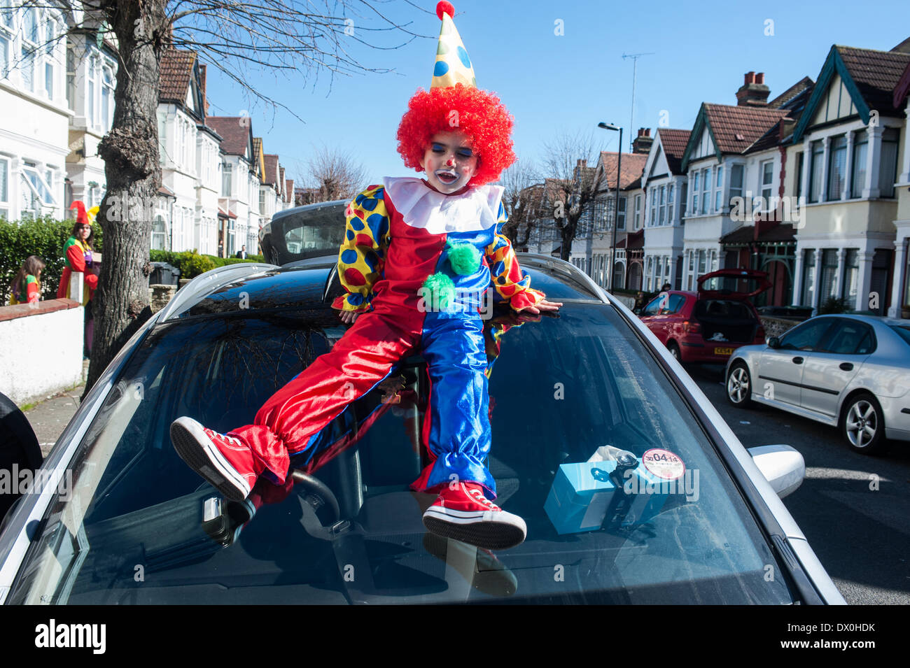 Londra, Regno Unito. Il 16 marzo 2014. Shaya, 4, vestito con un costume da clown si siede su una vettura durante la festa di Purim. Credito: Piero Cruciatti/Alamy Live News Foto Stock