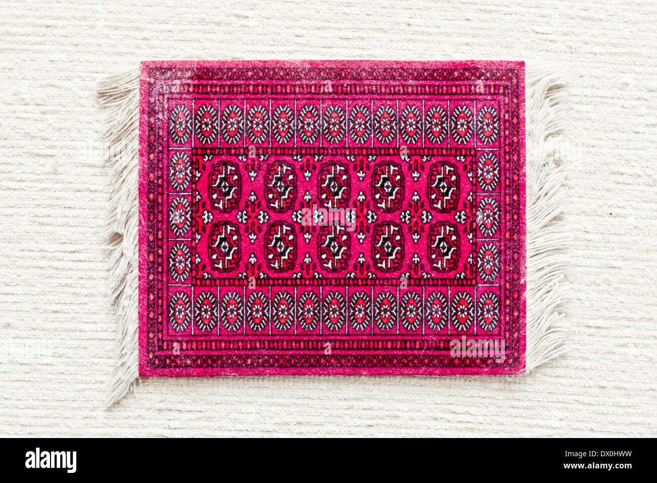 Un rosso tappeto asiatica su un panno bianco superficie Foto Stock