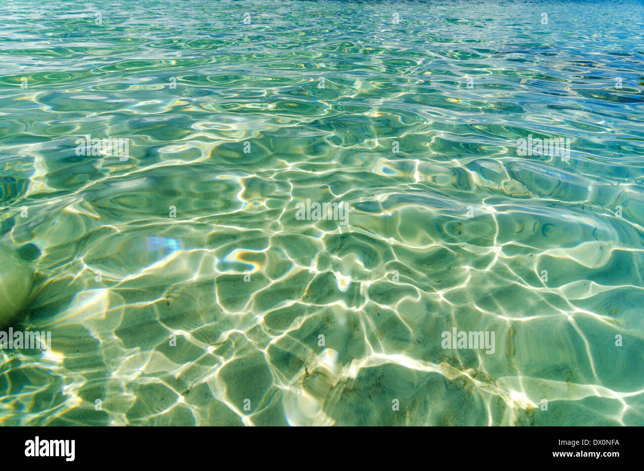 Riflettendo la luce del sole in una bellissima cristalline acque dei Caraibi Foto Stock