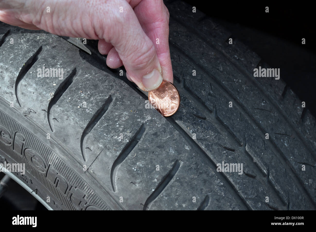 Controllare la profondità del battistrada di pneumatici vettura utilizzando una moneta Foto Stock