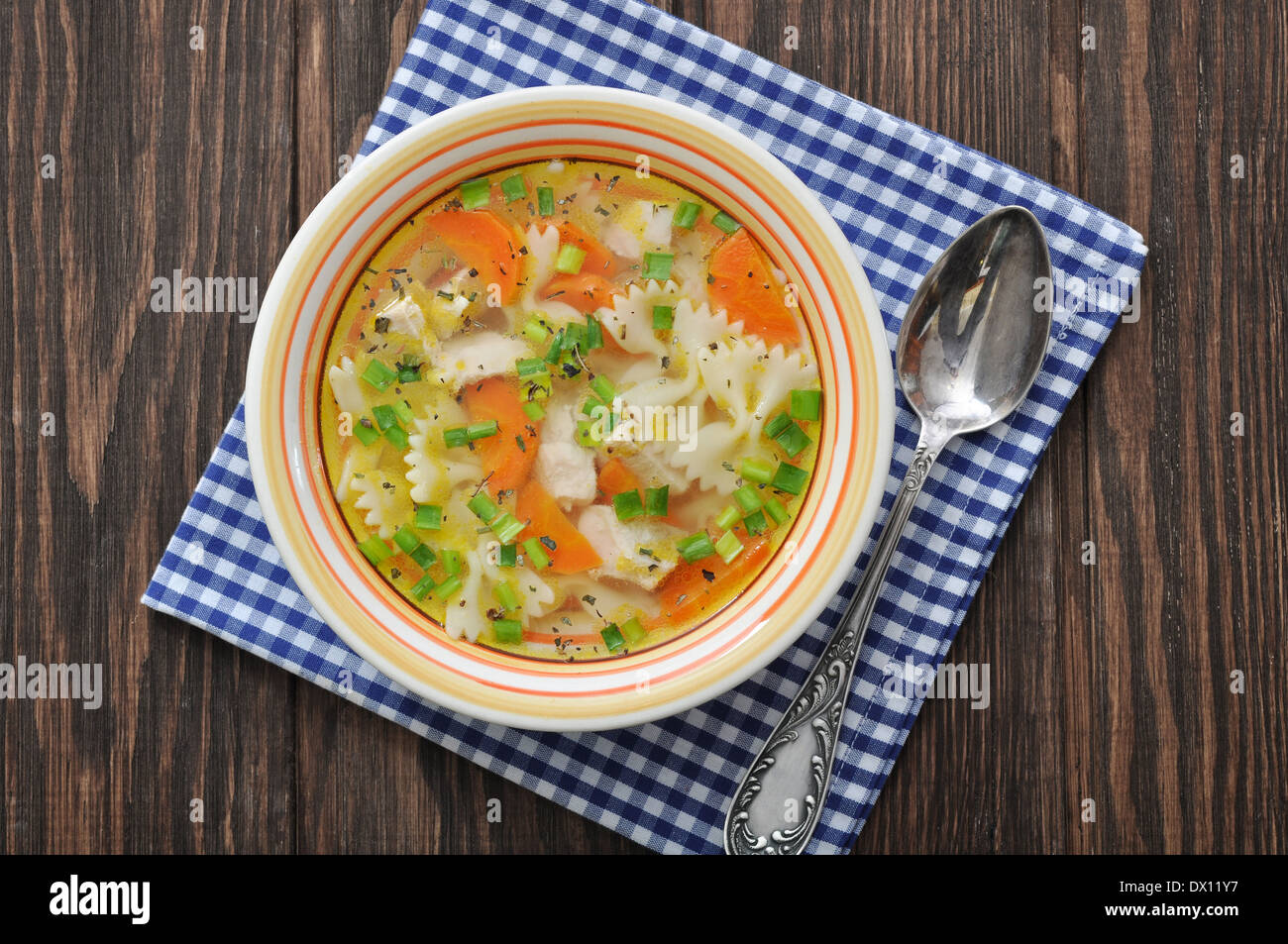 Zuppa di pollo con farfalle di pasta nella ciotola sul tavolo di legno Foto Stock