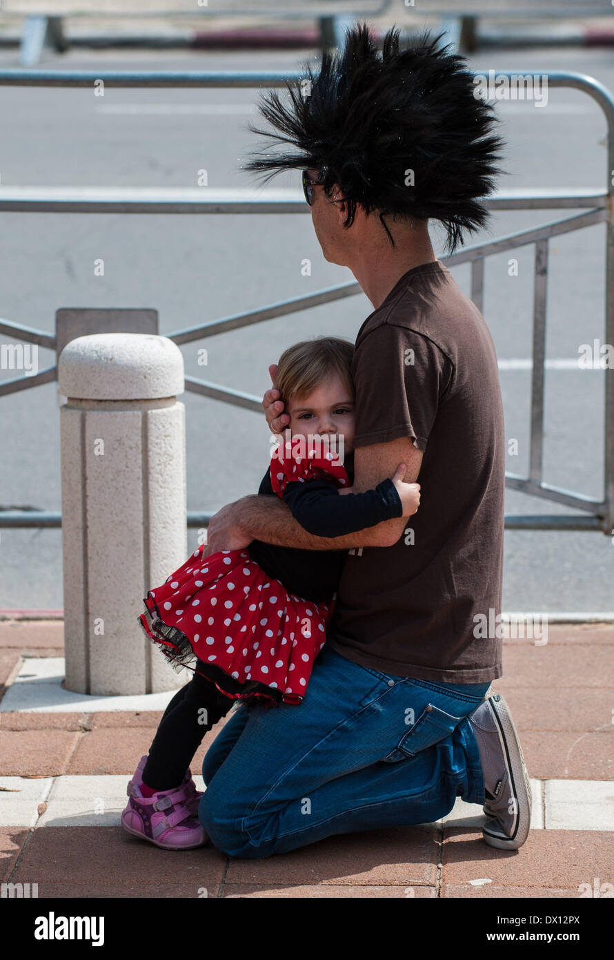 Holon, Israele. 16 marzo, 2014. Una ragazza israeliana avvolge il suo padre durante Adloyada Holon Purim Parade 2014 in Holon, Israele centrale, il 16 marzo 2014. Purim, celebrato quest anno dal tramonto, 15 marzo al calar della sera, 16 marzo è una festa ebraica che commemora la liberazione del popolo ebraico in persiano antico impero in cui un appezzamento è stata formata per distruggerli. Credito: Xinhua/Alamy Live News Foto Stock