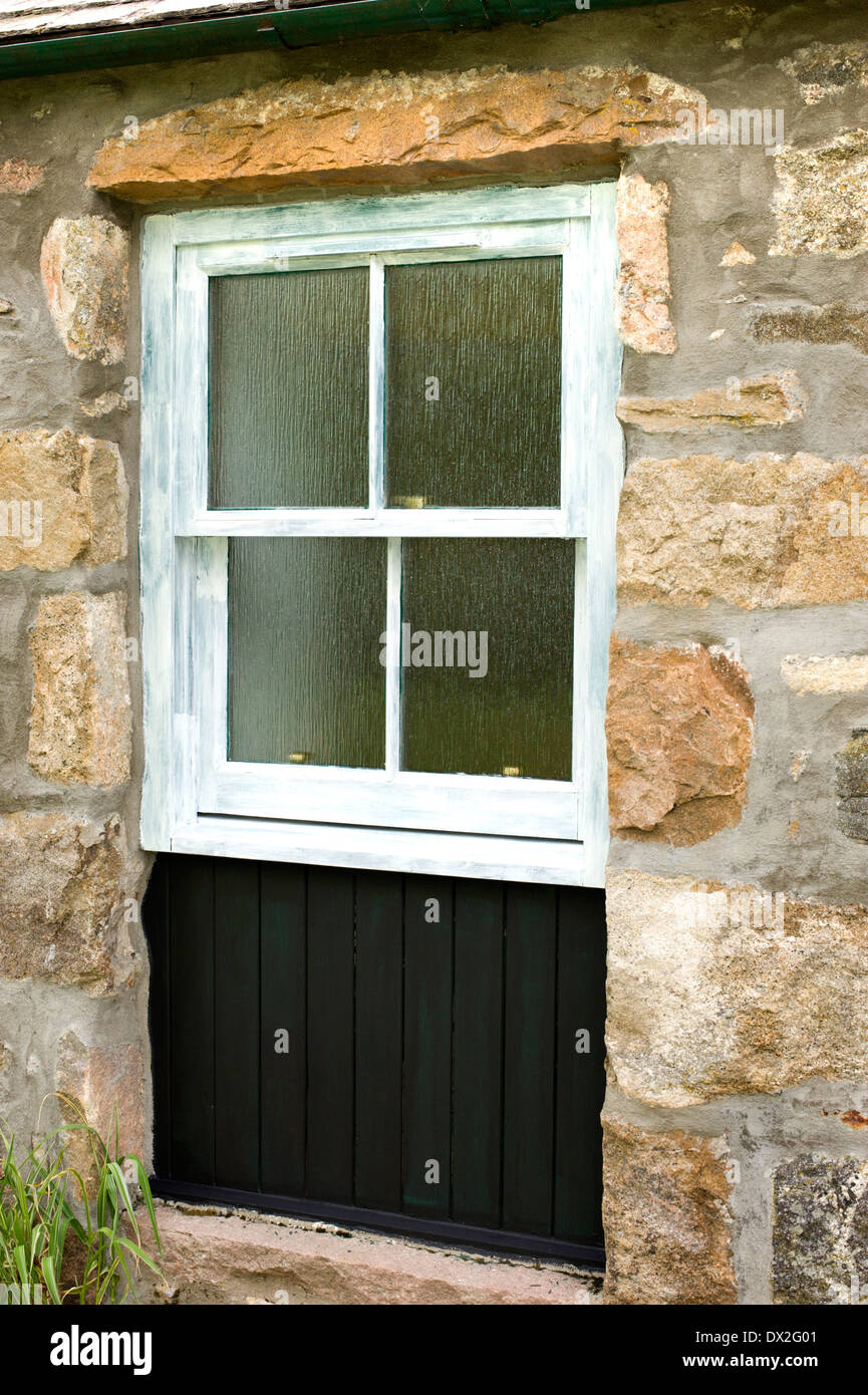 L'immagine di una finestra ad anta e imbarco in vecchio cottage in pietra undercoated e pronto per essere verniciato Foto Stock
